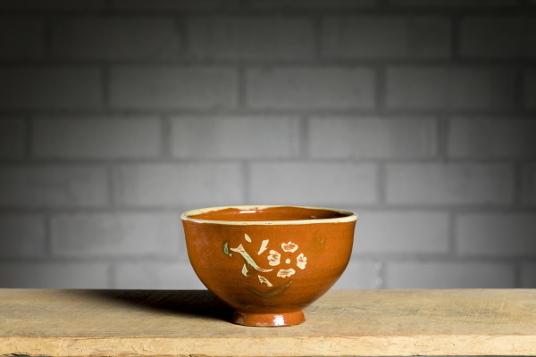 Bol o escudella: tant per beure o per menjar sopes. Bany d’engalba vermella de base, decoració amb engalba blanca aplicada a trepa, vora perfilada amb fusta i vernís. TM. 1806