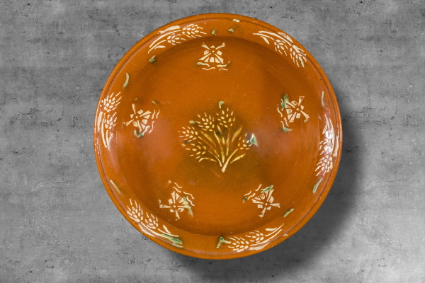 Plata fonda: per preparar i servir viandes. Bany d’engalba vermella de base, decoració amb engalba blanca aplicada a trepa i vernís. Col·lecció particular. | © Jordi Geli / Terracotta Museu