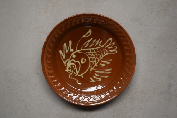 Plat de l'escórpora . Terra vermella, engalbes i vernís. Torn. Decoració a xeringa. Josep Vilà Clara, 1959. Ø 24 cm. TM. 10398.