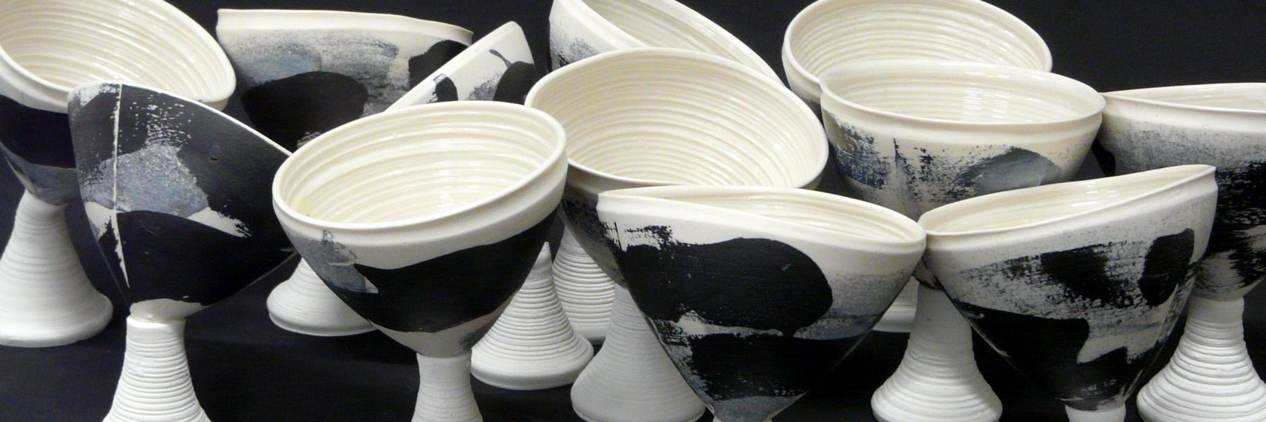 La pieza consta de un conjunto de copas de cerámica apiladas, colores blancos y negros