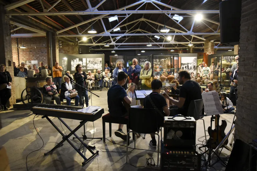 Imagen de la segunda edición de Terracotta en concert (2024) | © Anna Pascual Tres músicos, un adulto y dos niños, junto a la exposición permanente, con un numeroso público delante.